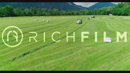 Aerial view of several tractors cultivating a field