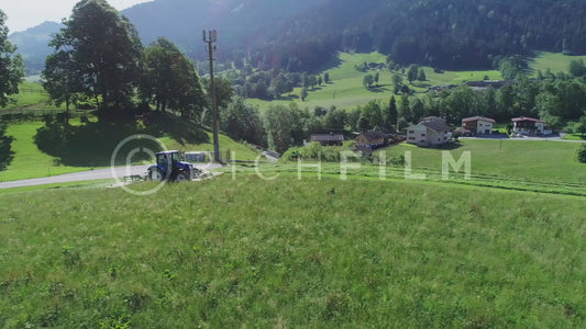 Aerial view of a tractor mowing a field from above