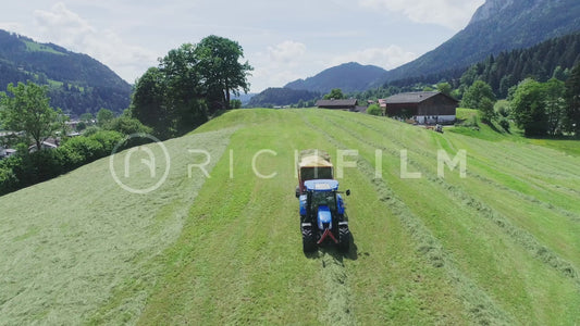 Aerial view of a tractor in the field collecting grass