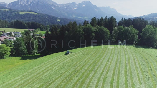 Aerial view of a tractor in the field turning hey