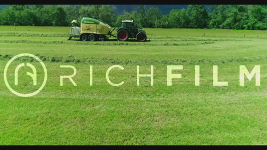 Aerial view of a tractor baling bales from the side