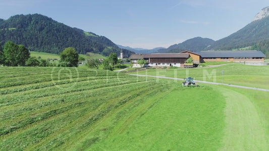 Aerial view of a tractor turning the grass in the field