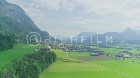 Aerial view of a village surrounded by mountains and cloudy sky - V2