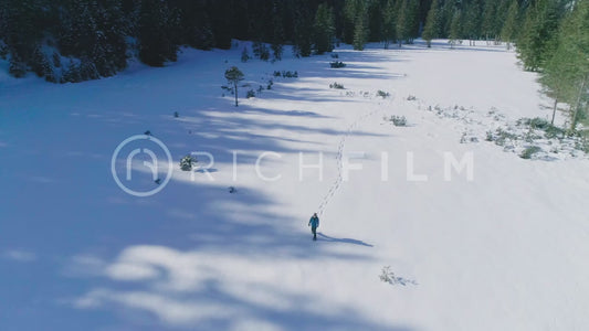 Aerial view of a hiker walking in a deep snow landscape