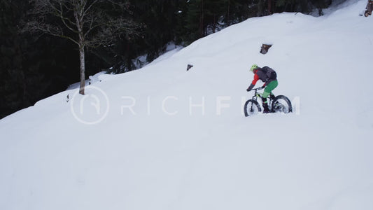 Aerial view of cyclist riding through deep snow in winter - V2