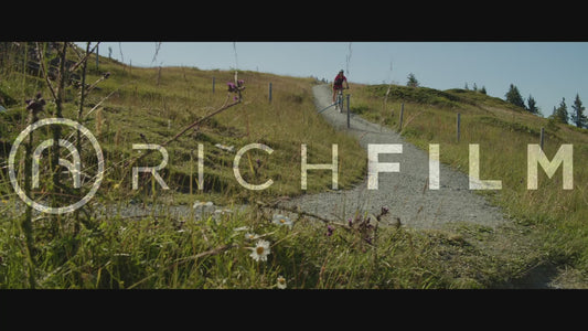 Slow motion shot of a cyclist riding down a hill in summer