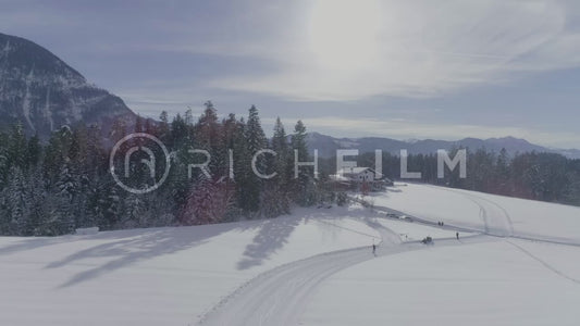 Aerial view of a cross-country skiing track with a beautiful landscape with forest and sun