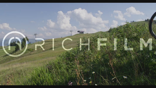 shot of a landscape with a meadow and a mountain railway and a biker bike on the side