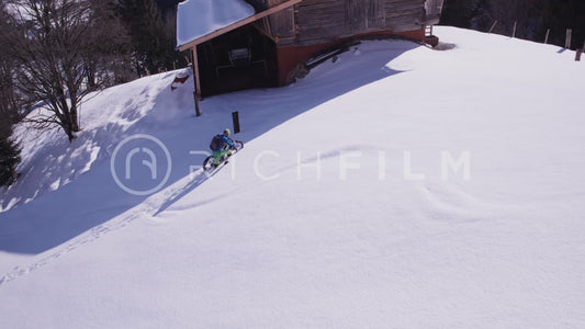 Aerial view of a mountain biker standing firm and pushing his bike in deep snow in winter