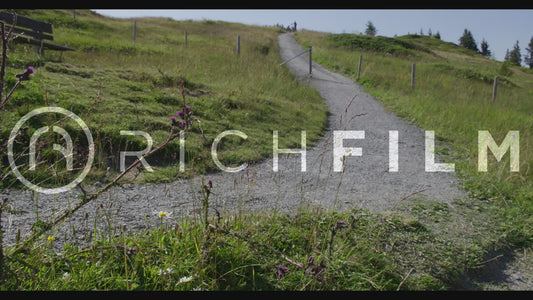 Shot of a mountain biker riding over a hill with a clear sky