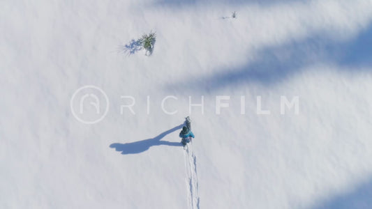 Aerial view of a hiker in a deep snow landscape from the bird's eye view