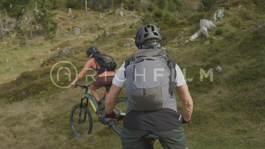 Slow motion shot of mountain bikers riding over hills