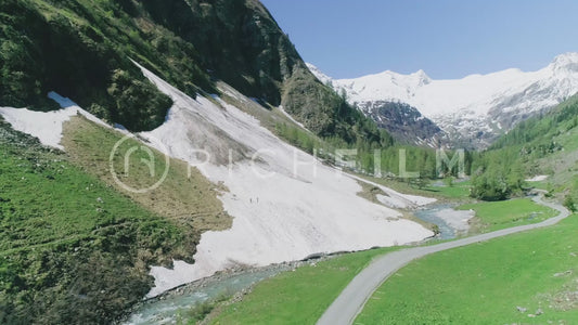 Aerial view of a mountain range with a stream and a fores