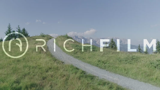 Aerial view of a mountain biker on a dirt track towards the alp