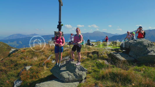 Drone shot of people at the summit cross in a mountainous landscape