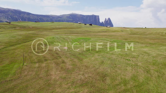 Aerial view of the Dolomites and hilly landscape with wooden huts