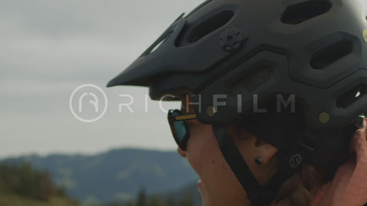 Close-up of a smiling cyclist with the Alps in the background