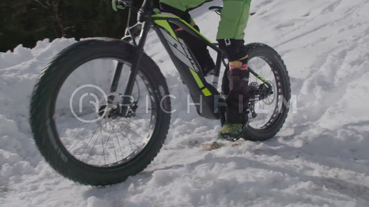 Slow motion shot of a mountain biker in deep snow close-up