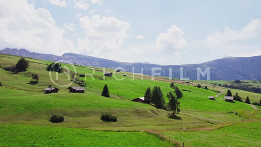 Aerial view of a mountain landscape with huts in the Dolomites under a blue sky