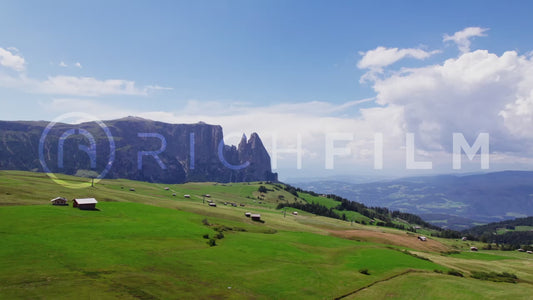 Aerial view of the Dolomites with partly cloudy blue sky and hilly landscape