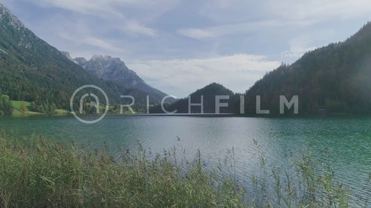 Aerial view of a radiant lake with the Alps and a cloudy sky