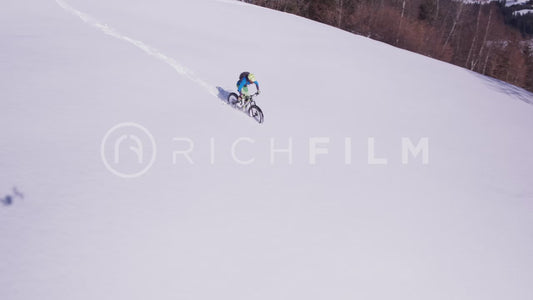 Aerial view of cyclist riding through deep snow in winter