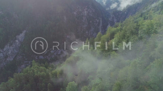 Aerial view of cloudy mountains and green forest