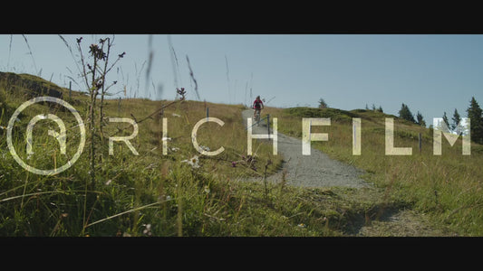 Slow motion shot of a cyclist riding down a hill in summer - V2