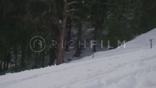 Slow motion shot of a mountain biker in deep snow with extreme snow splashes