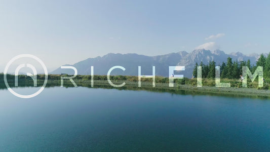 Aerial view of cyclists cycling around a lake in summer view towards the Alps